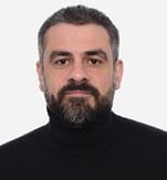 Headshot of mohamed Sahloul wearing a black poloneck against a white background