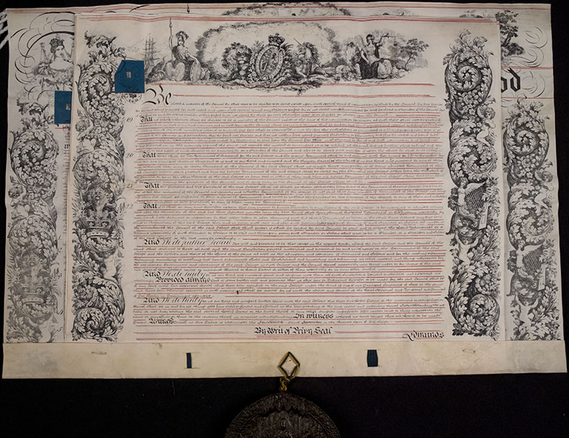 A formal document with elaborate decorations and calligraphy, with an attached wax seal